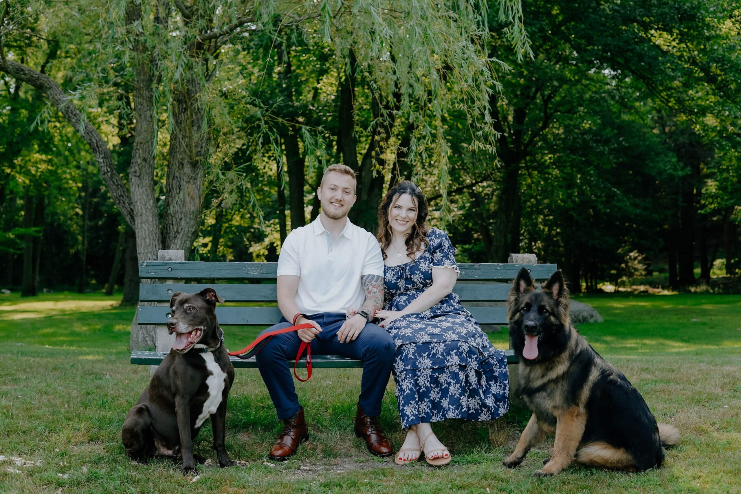 Jordan and Roxie on a park bench with their two dogs