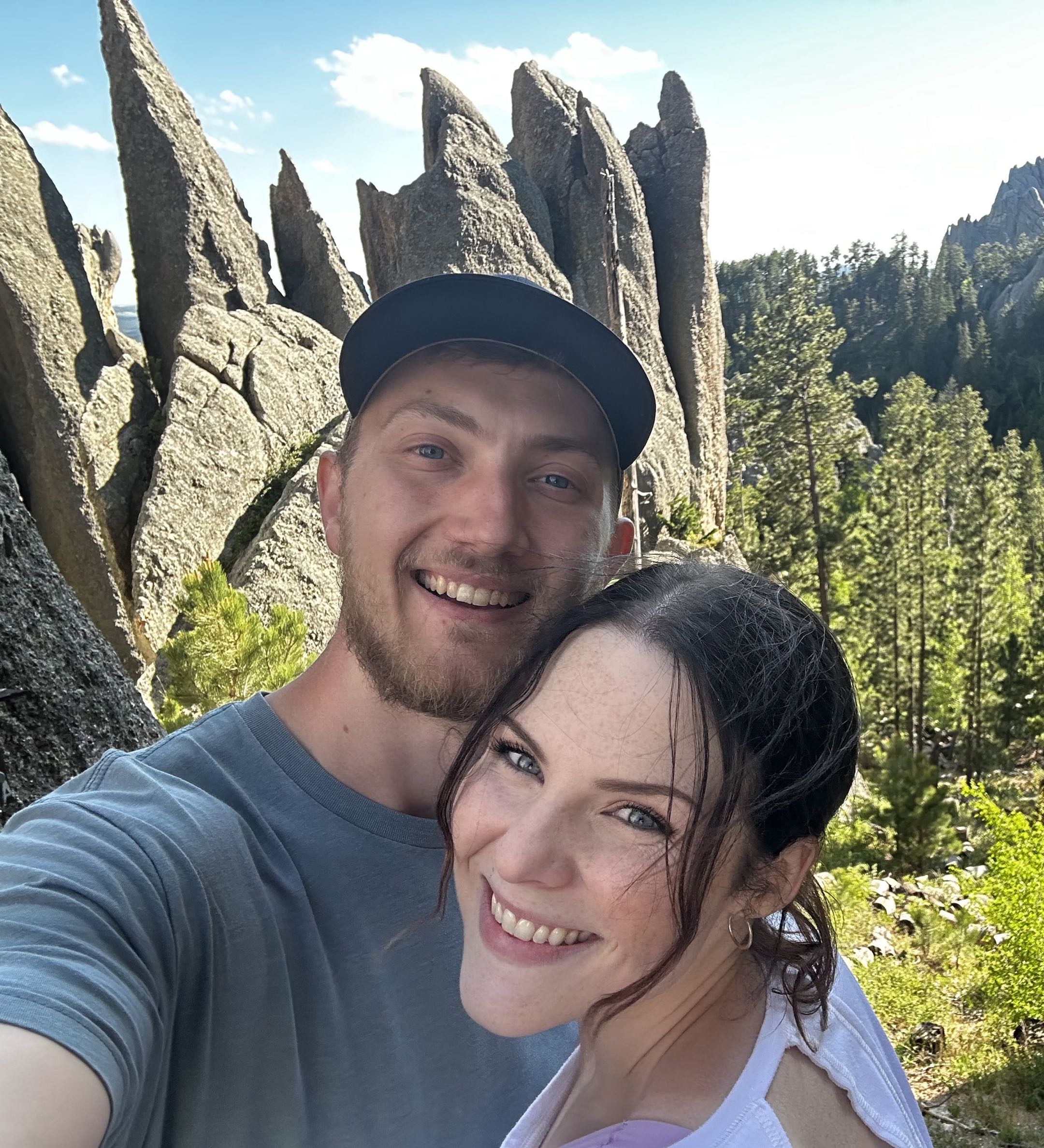 Jordan and Roxie smiling on a hike among granite spires in the Black Hills