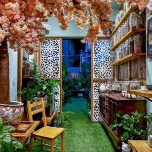 Pink blossoms, carved screens and a carpet of green inside a tea shop.